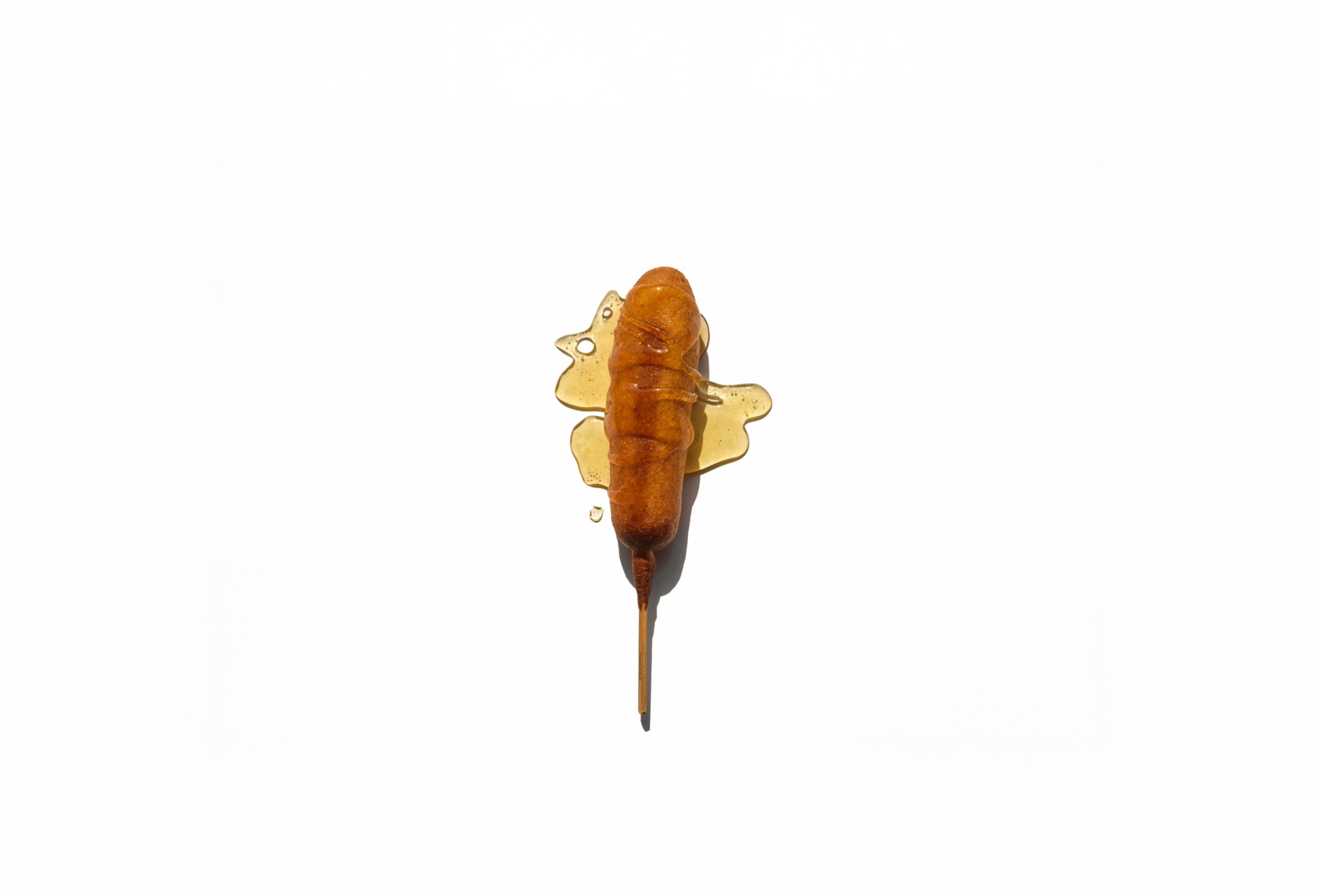 Golden brown Pogo drizzled in honey on white background