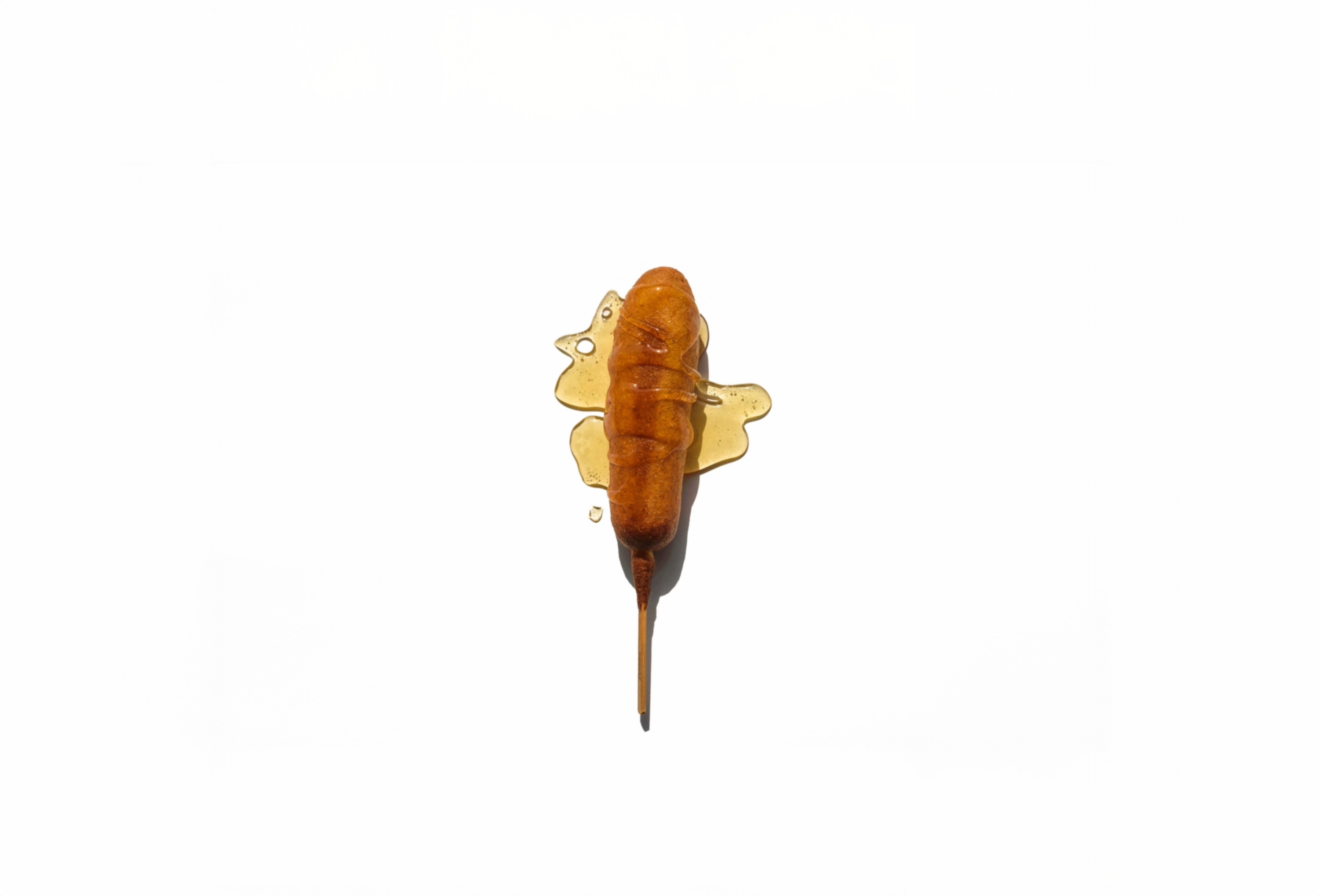 Golden brown Pogo drizzled in honey on white background